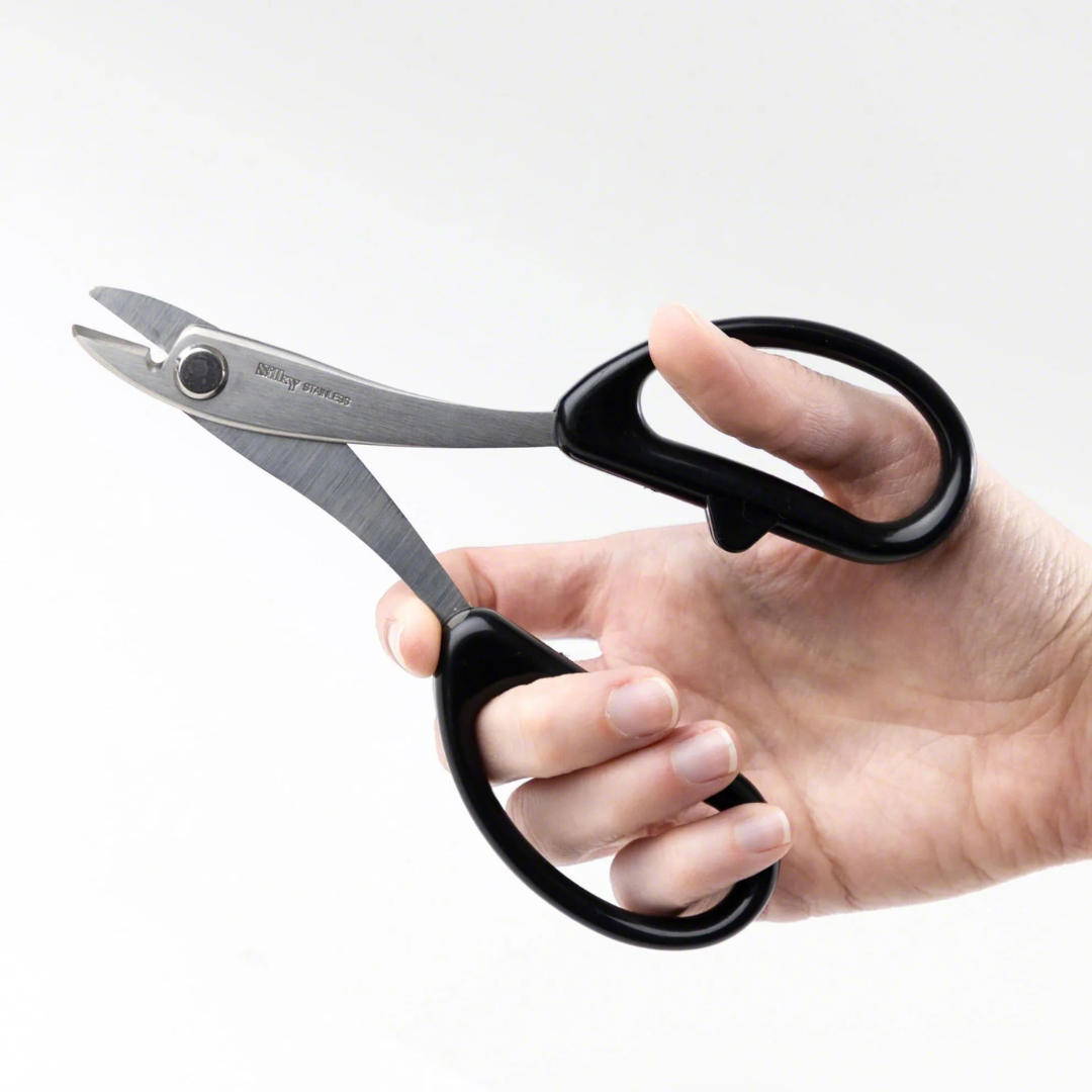 Hand holding Wazakura stainless steel scissors for cutting bonsai training wire